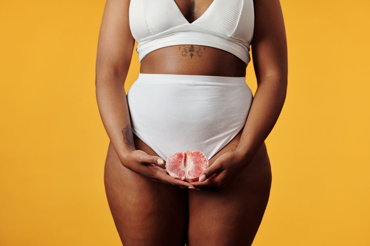 gallery-3 Artistic photo of a woman in underwear holding a pomelo against a yellow background.