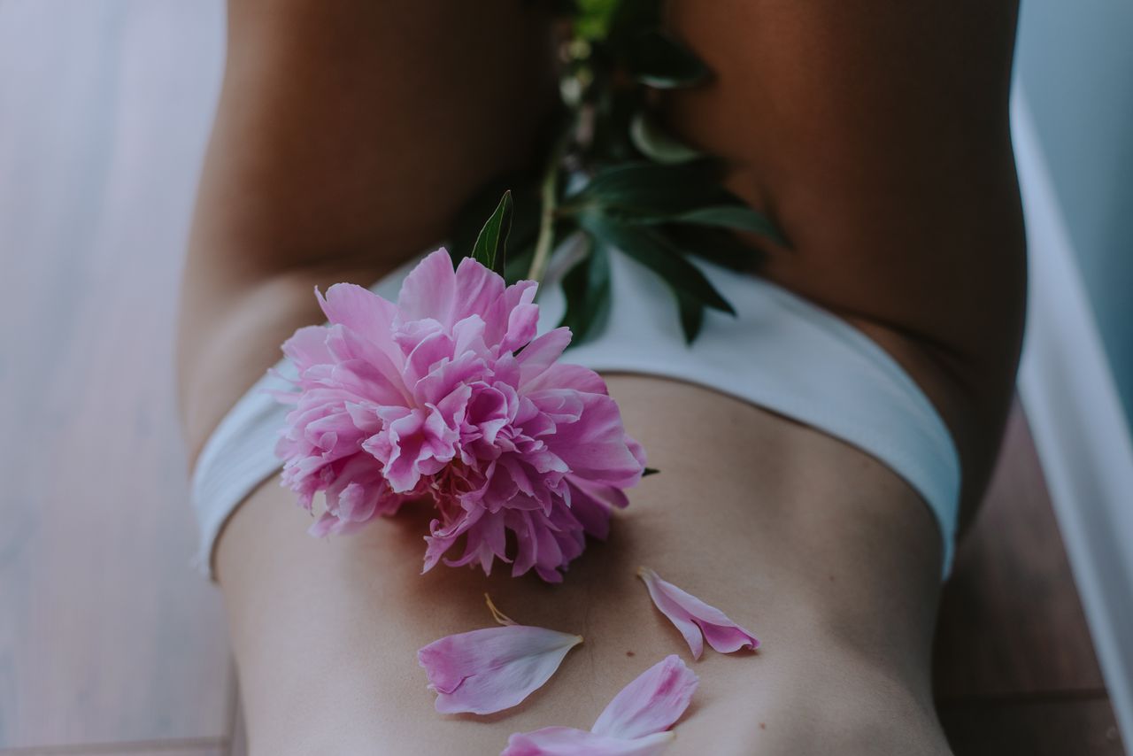 gallery-4 Artistic image of a woman with peony flower petals on skin, capturing sensuality and elegance.